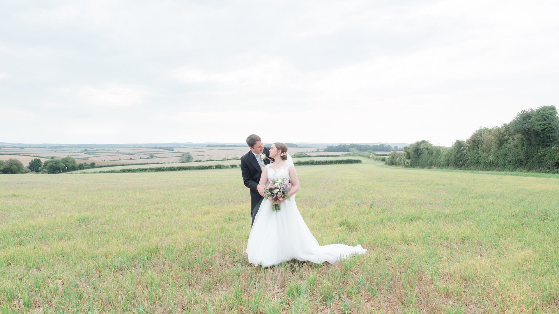 Michaela and Rupert gaze adoringly at each other in a field