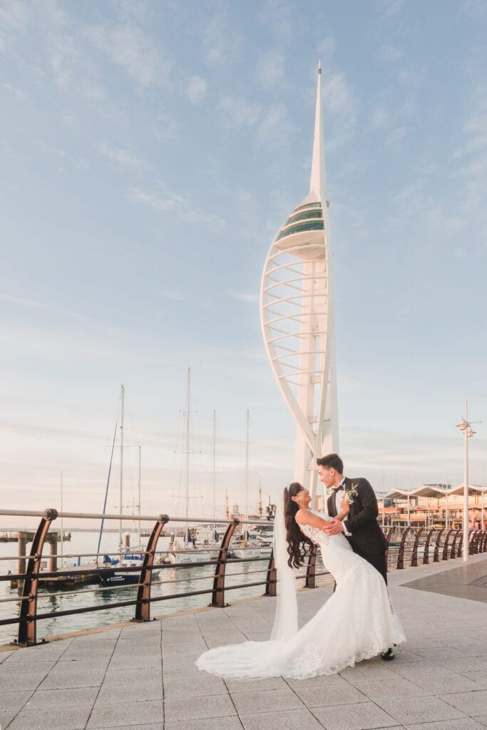 Groom dips bride in front of the Spinnaker Tower in Portsmouth at sunset.