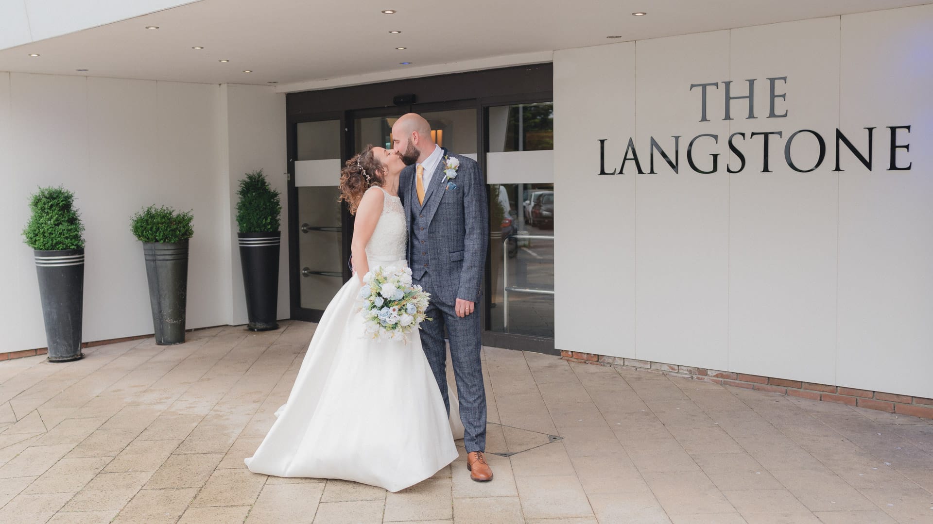 Langstone Quays wedding – bride and groom kiss by hotel entrance