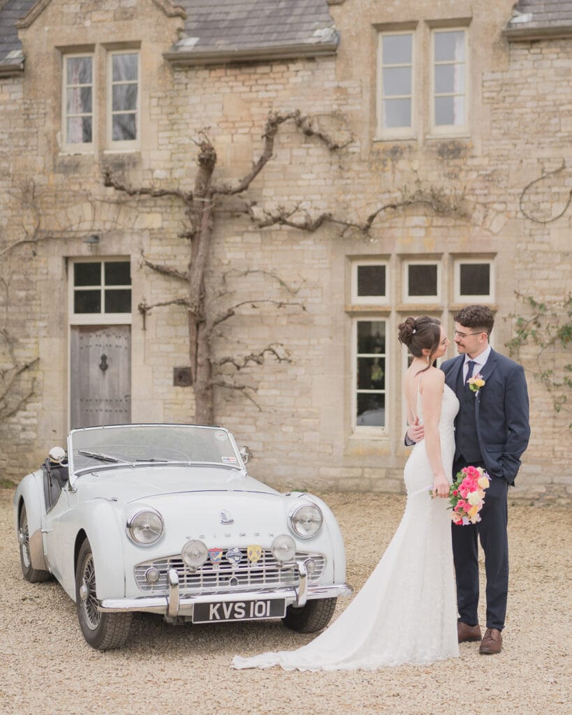 Bridal couple and vintage Triumph two-seat sports car at Euridge Manor