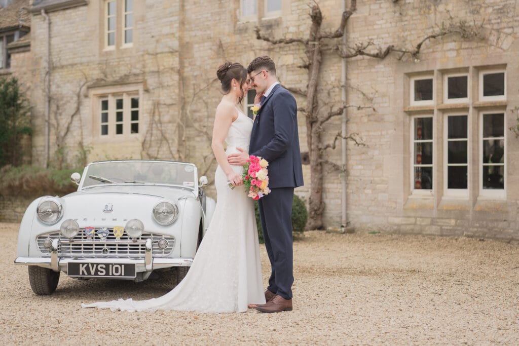 Couple and vintage Triumph two-seat sports car at Euridge Manor