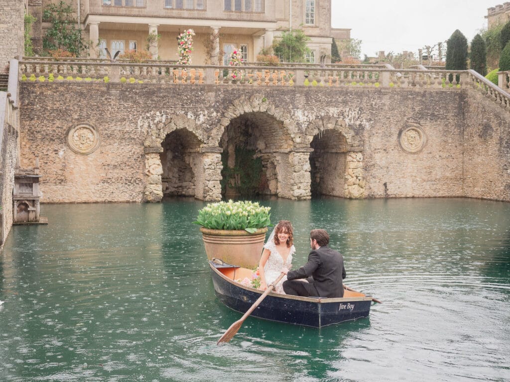Bridal couple in rowing boat on the moat at Euridge Manor