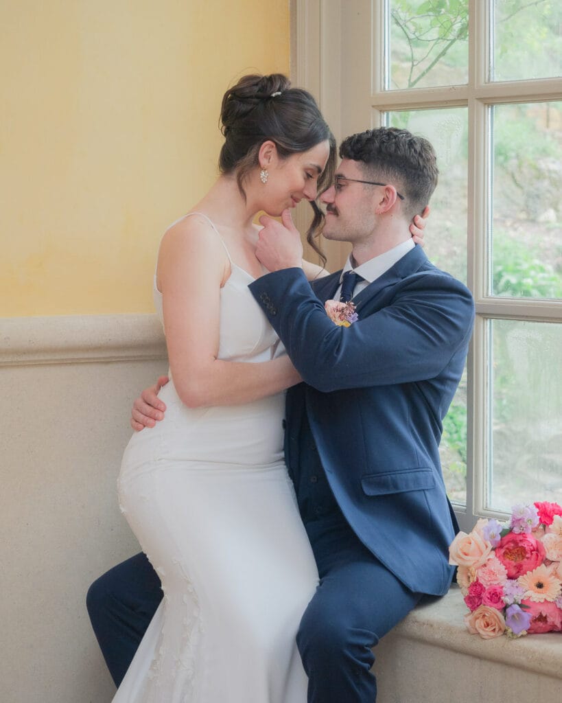 Bridal couple make out in corner of great hall in Euridge Manor